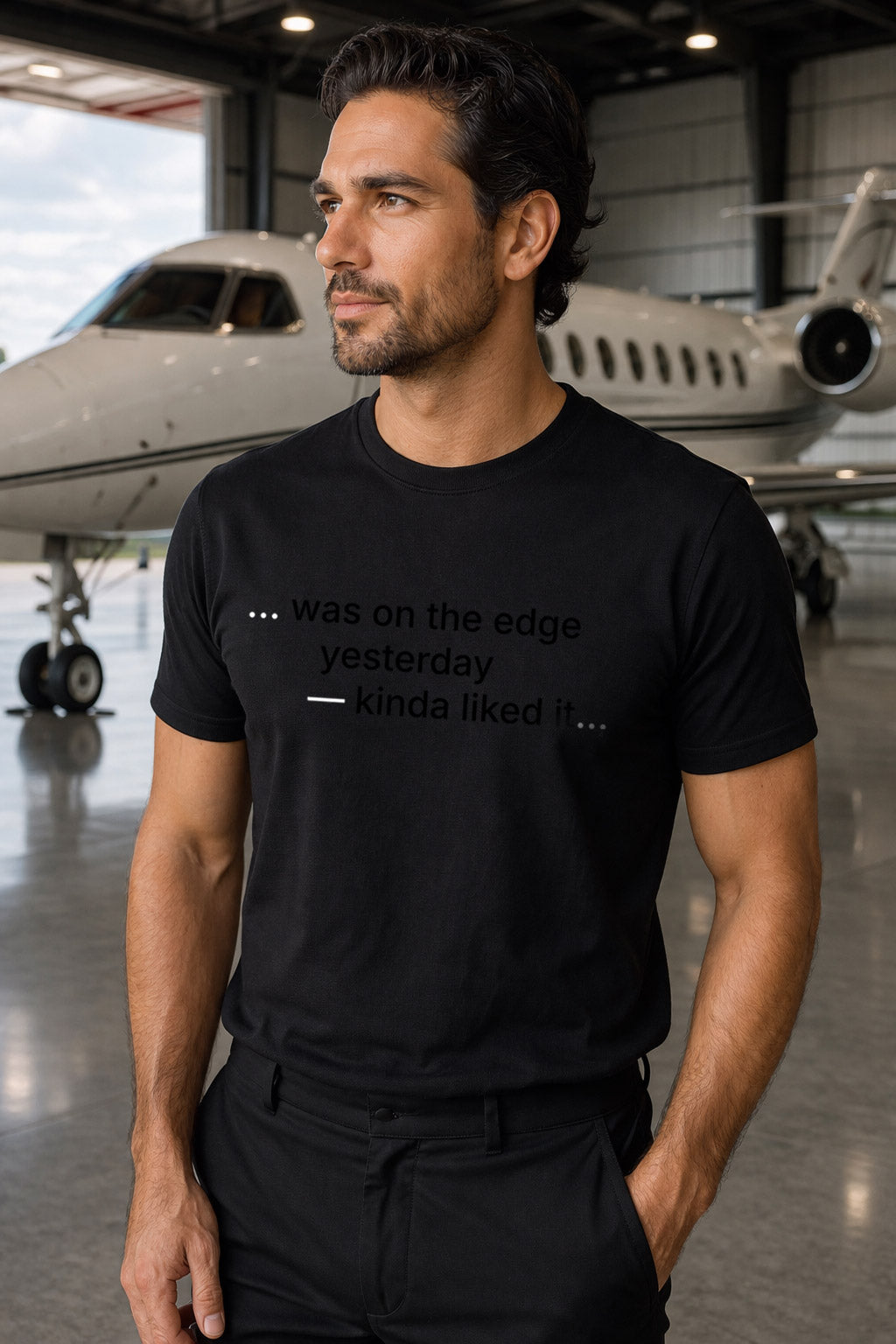 Handsome man wearing was on the edge yesterday kinda liked it near a private jet testing his limits.