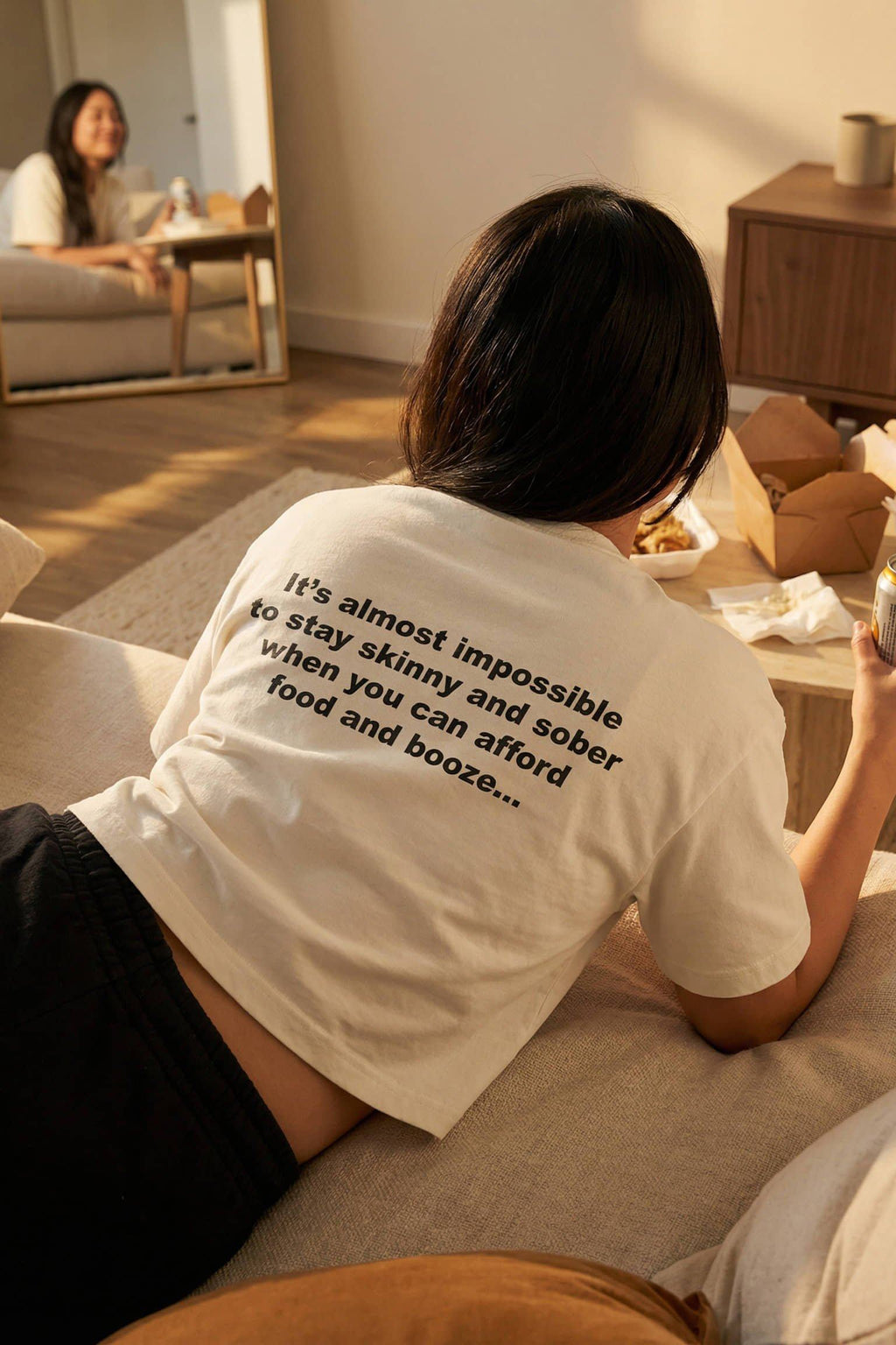 Relaxed woman eating takeout wearing almost impossible to stay skinny and sober embracing indulgences, a perfect gift.