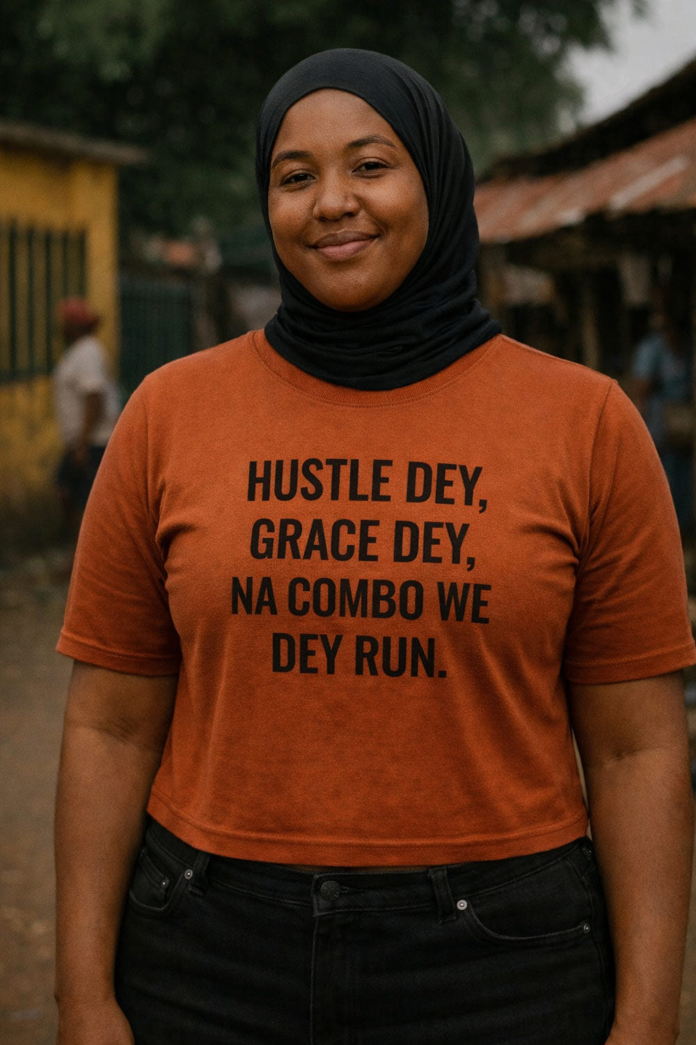 Smiling woman stand wear hustle dey grace dey na combo we dey run shirt for lasting victory.