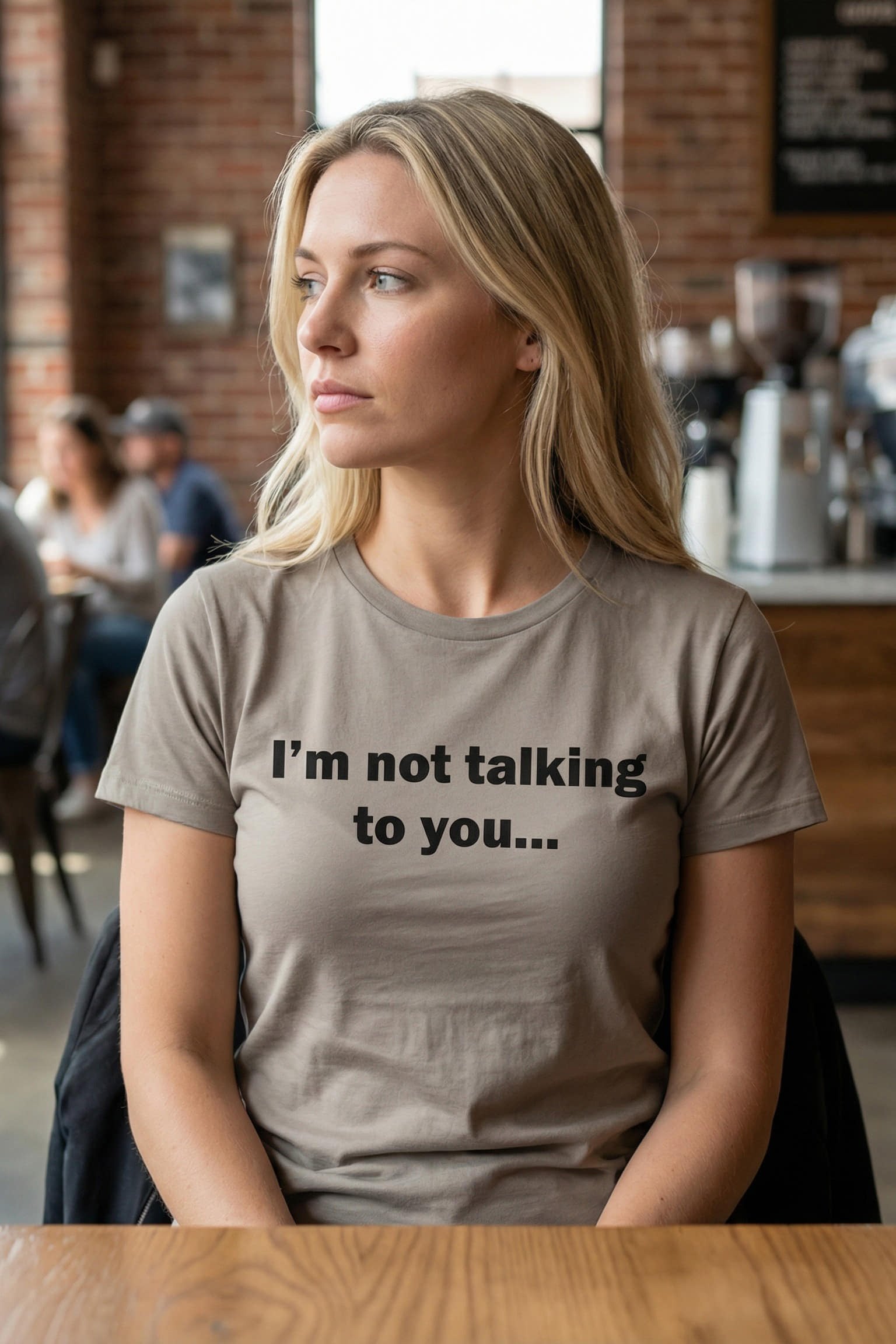 Calm woman sitting in a cafe wearing I'm not talking to you protecting her peace, perfect introvert gift.