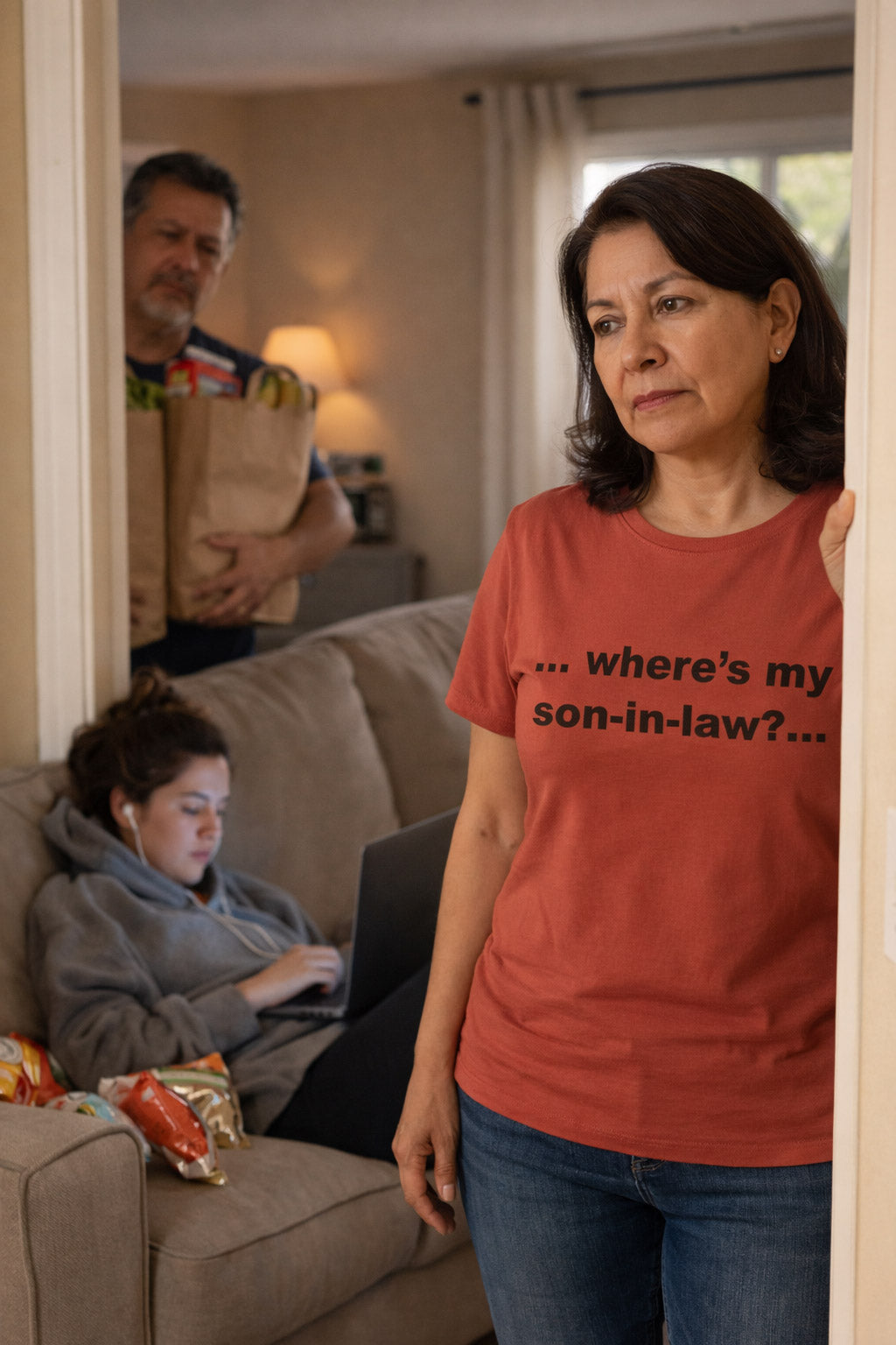 Mother standing in a doorway wearing the where's my son-in-law shirt expressing playful favoritism.