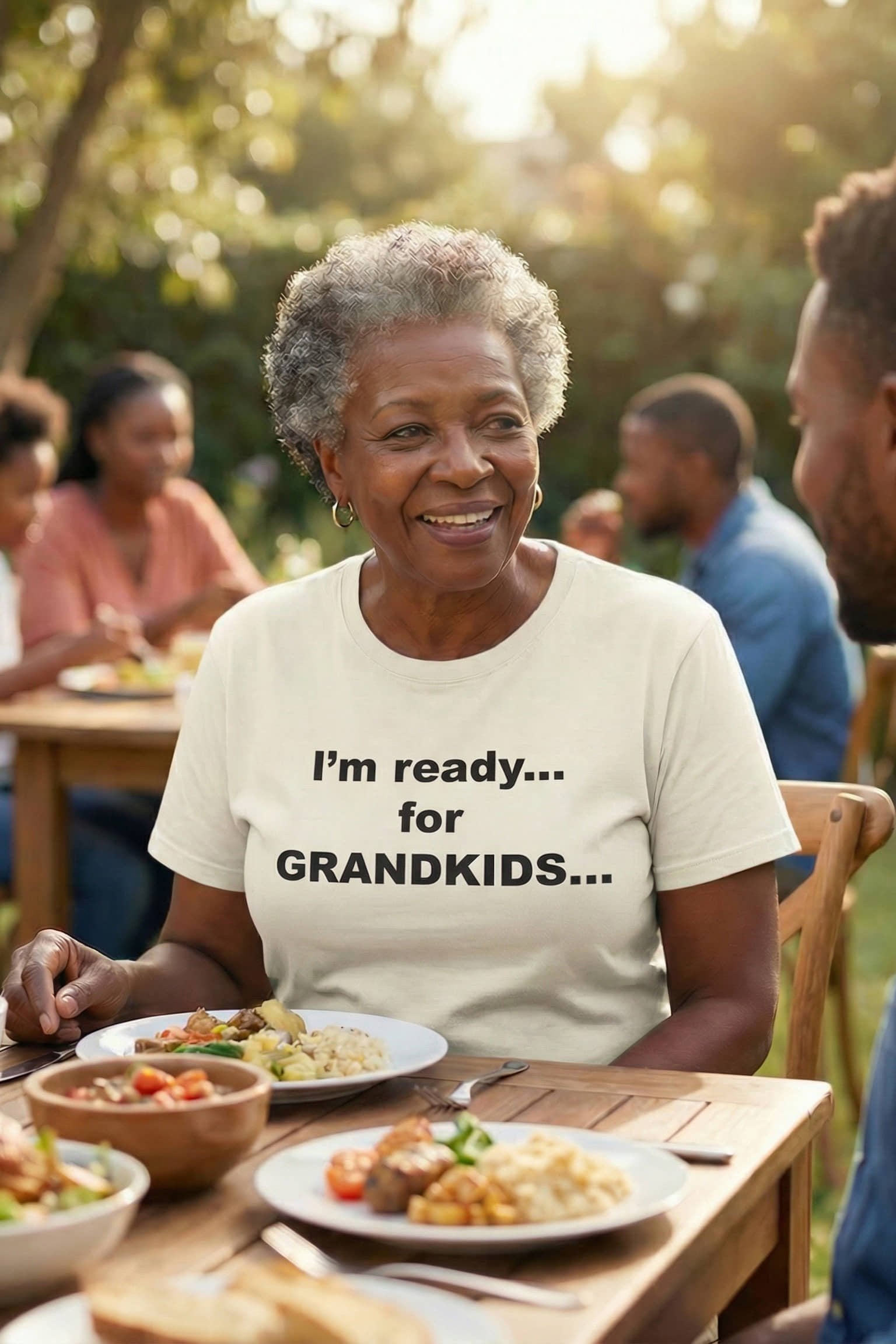 Smiling woman at a family gathering wearing I'm ready for grandkids sharing her abundant love, perfect gift.