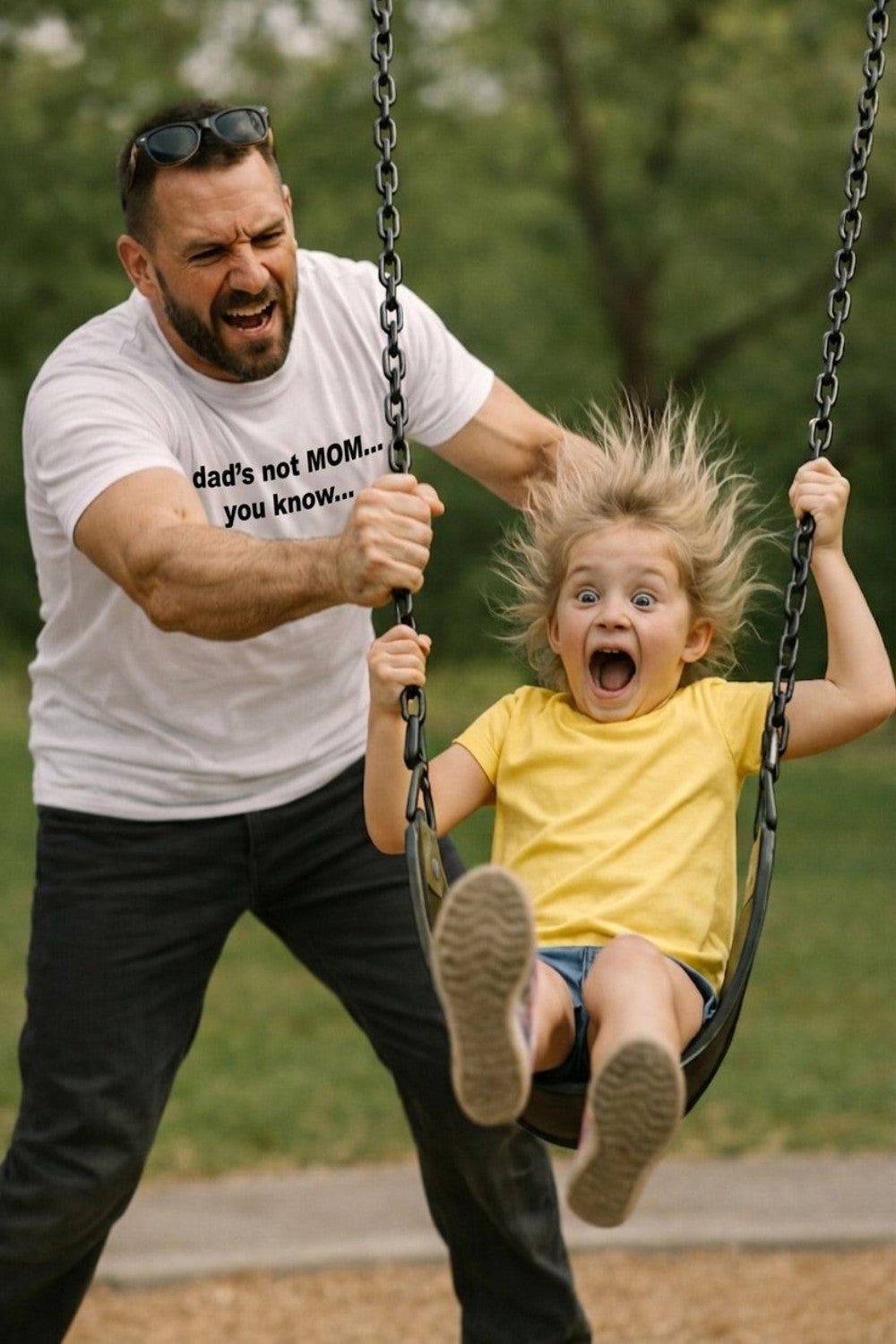 Energetic father pushing a screaming child on a swing wearing dad's not mom you know, perfect gift.