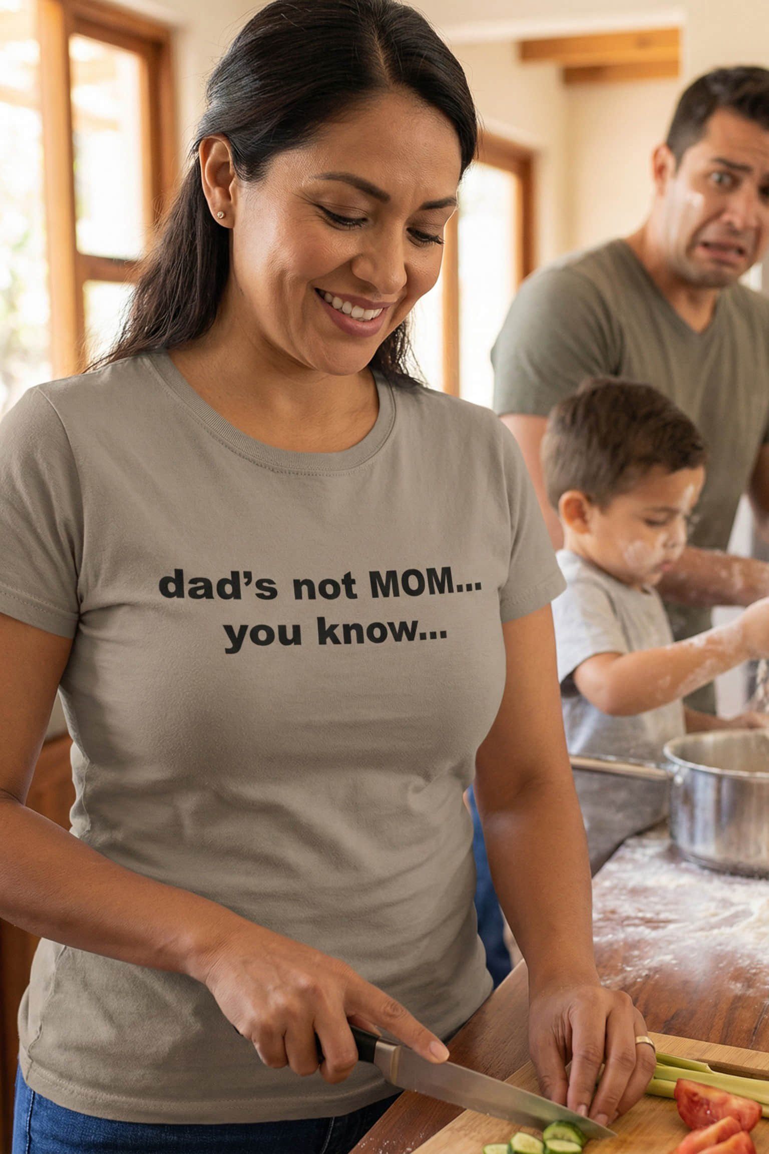 Smiling woman cooking wearing dad's not mom you know while her family panics, an ideal parent gift.