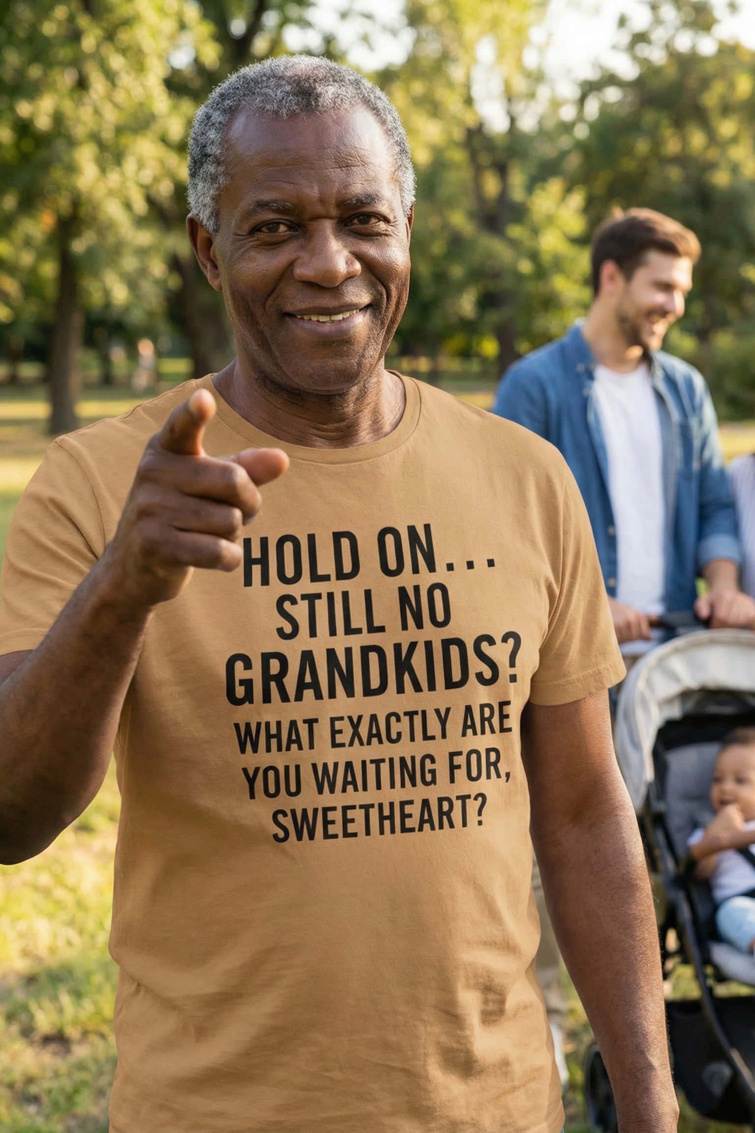Smiling older man pointing outdoors wearing hold on still no grandkids showing a heart overflowing, perfect gift.