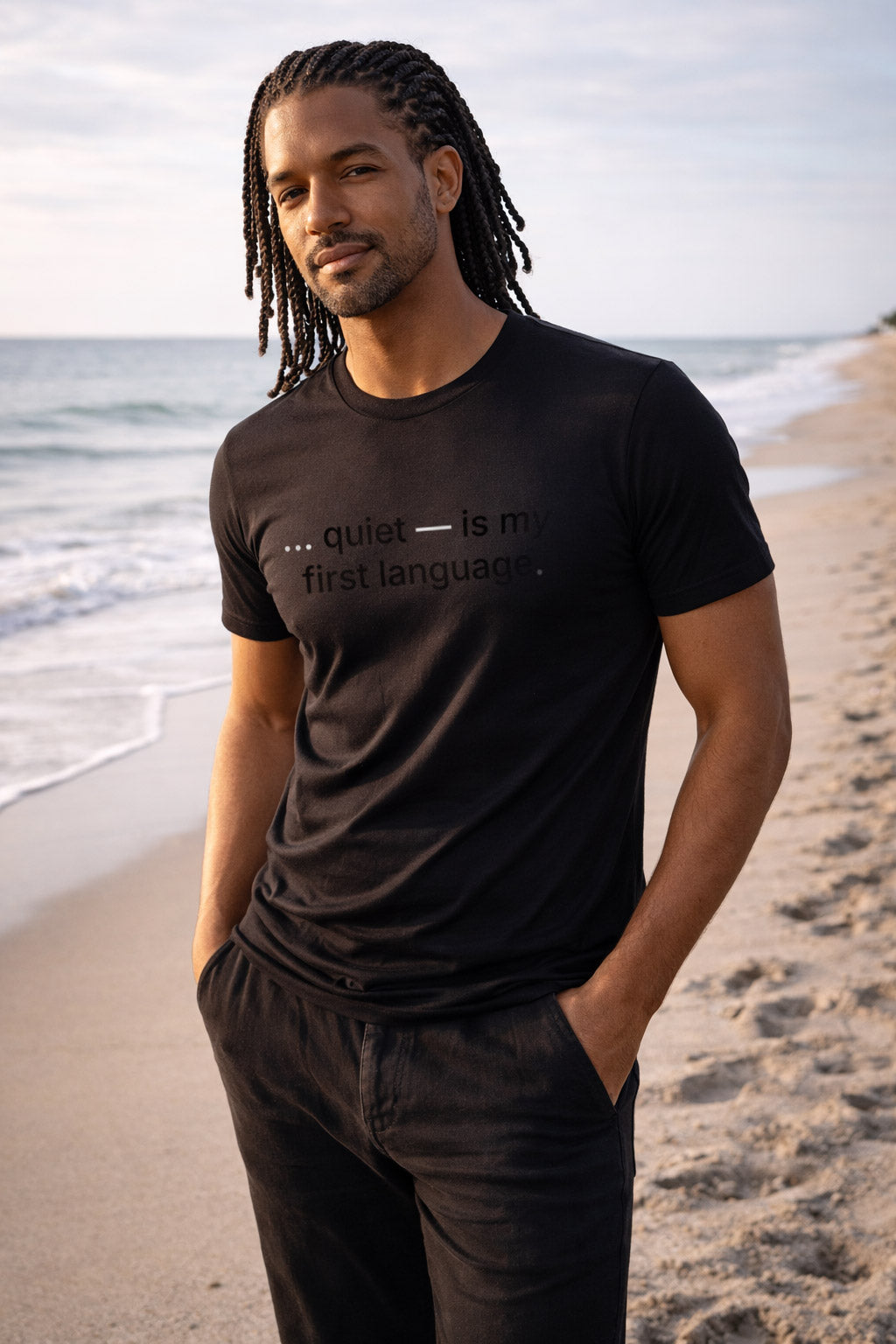 Confident man wearing quiet is my first language on the beach observing a richer understanding of the world.