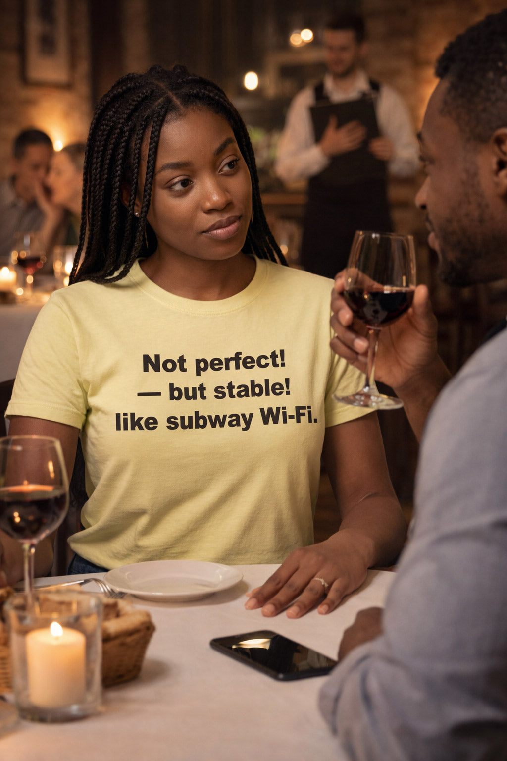 Calm woman at dinner wearing the not perfect but stable like subway Wi-Fi shirt embracing her quirks.